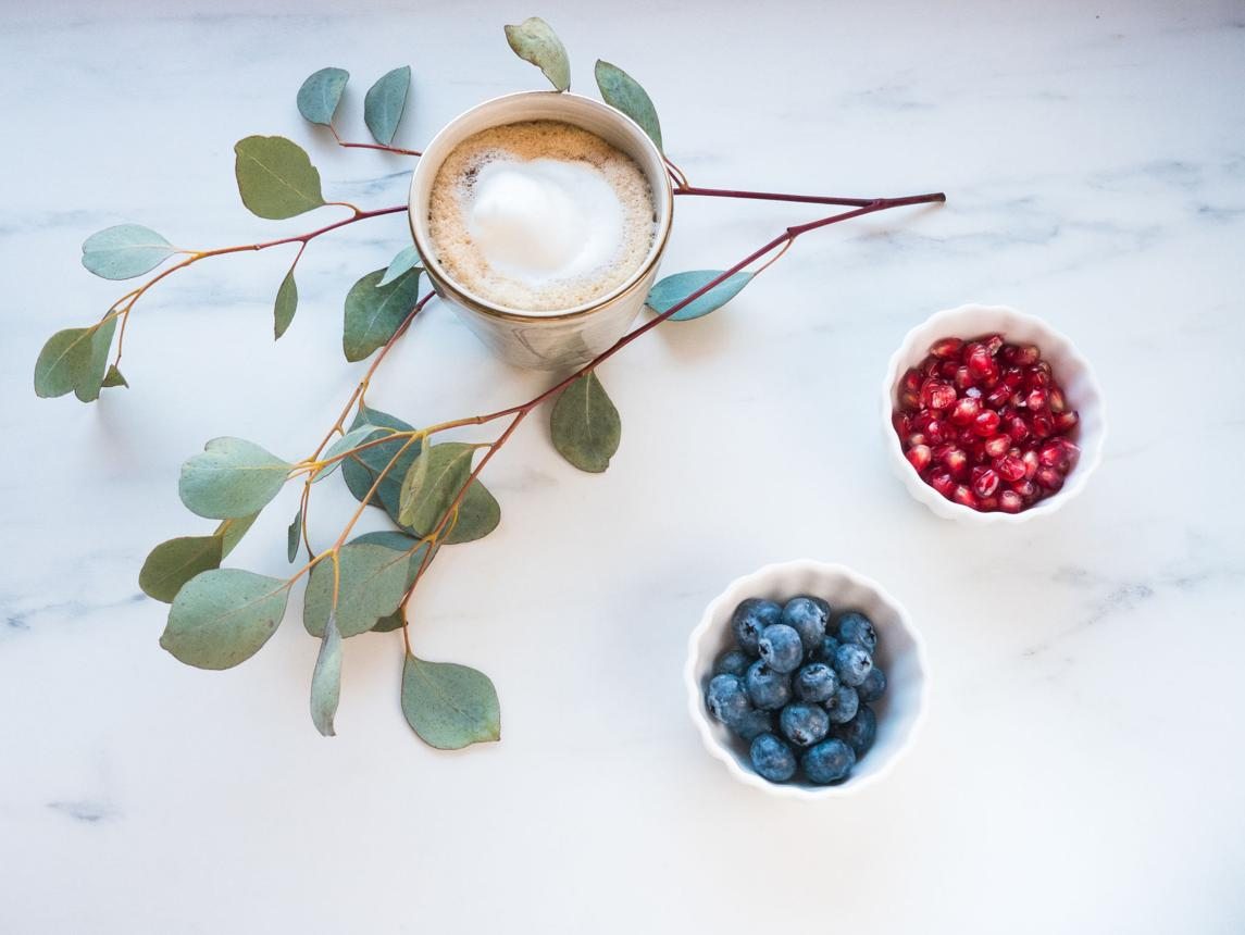 Koffiekop met eucalyptus, blauwe bessen en granaatappelpitten
