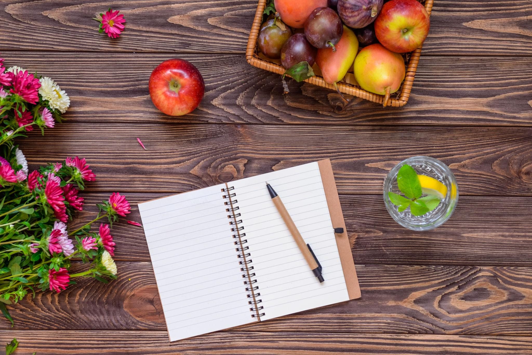 Notitieboek met fruit en water als symbool voor persoonlijke leefstijlbegeleiding